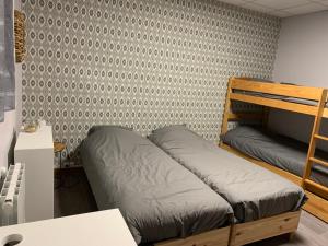 a bedroom with two bunk beds and a desk at Hotel Caplandes in Capbreton