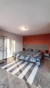 een slaapkamer met een bed en een rode muur bij Les Jardins Ducarouge 3 in Digoin