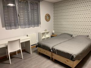 a bedroom with a bed and a desk and a desk at Hotel Caplandes in Capbreton