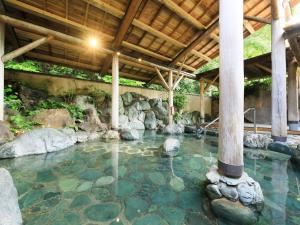 a pool of water with rocks and a wooden ceiling at ＳＰＲＩＮＧＳ ＶＩＬＬＡＧＥ - Vacation STAY 67329v in Oyama