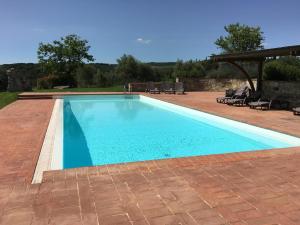 - une piscine d'eau bleue dans une terrasse dans l'établissement Ferienwohnung für 2 Personen ca 68 qm in Castelnuovo Berardenga, Toskana Chianti, à Castelnuovo Berardenga