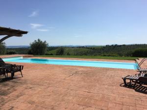 a swimming pool with chairs on a patio at Ferienwohnung für 2 Personen ca 68 qm in Castelnuovo Berardenga, Toskana Chianti in Castelnuovo Berardenga