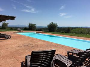 - une piscine avec 2 chaises longues à côté dans l'établissement Ferienwohnung für 2 Personen ca 68 qm in Castelnuovo Berardenga, Toskana Chianti, à Castelnuovo Berardenga