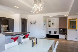 a kitchen with a white table and white chairs at Luxury Apartment Val di Monte in Malcesine