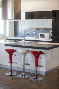 a kitchen with red bar stools and a sink at Luxury Apartment Val di Monte in Malcesine
