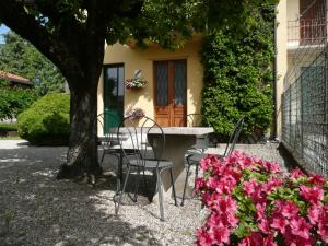 un tavolo e sedie di fronte a una casa con fiori di Piccolo Lago a Travedona