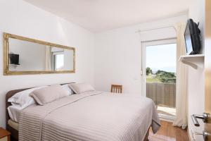 um quarto branco com uma cama e uma janela em GOLDY GREEN em Trogir