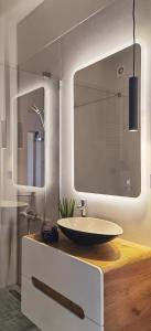 a bathroom with a sink and a mirror at Urban Sunset Apartment in Sibiu