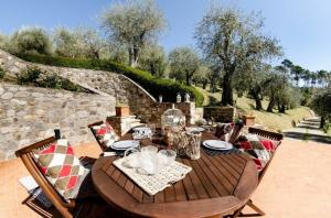 een houten tafel en stoelen op een patio bij Ferienhaus mit Privatpool für 7 Personen ca 200 qm in Capannori, Toskana Provinz Lucca in Capannori