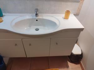 a white bathroom sink with a cup on it at studio francelu in Sainte-Anne