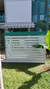 a white bench sitting in front of a house at studio francelu in Sainte-Anne