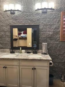 La salle de bains est pourvue d'un lavabo et d'un miroir. dans l'établissement Rustic Retreat New Cabin on 2 Acres Fully Fenced! Summer special 2 complimentary tickets to Bearizona offer expires July 31st 2024, à Williams