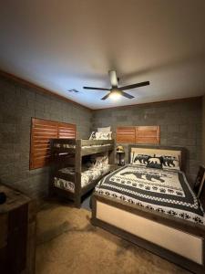 a bedroom with two beds and a ceiling fan at Rustic Retreat New Cabin on 2 Acres Fully Fenced! Summer special 2 complimentary tickets to Bearizona offer expires July 31st 2024 in Williams