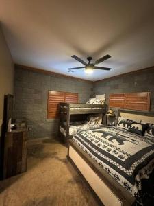 a bedroom with a bed and a ceiling fan at Rustic Retreat New Cabin on 2 Acres Fully Fenced! Summer special 2 complimentary tickets to Bearizona offer expires July 31st 2024 in Williams