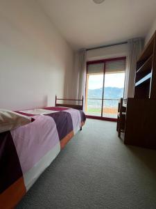 een slaapkamer met een bed en een groot raam bij Casa46 in Costa Volpino