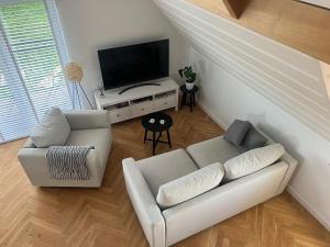 a living room with a couch and a flat screen tv at Chochołowska Przystań in Chochołów