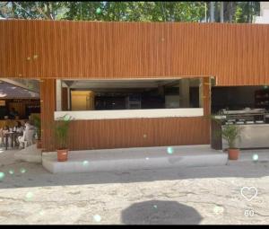 a restaurant with potted plants in front of a building at Hotel las marias de neiba in Cerro en Medio