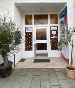uma porta da frente de um edifício branco com plantas em Apartment mit Rheinblick Koblenz em Koblenz