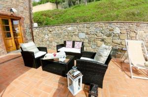 a patio with chairs and a table and a stone wall at Ferienwohnung für 4 Personen ca 55 qm in Palmata, Toskana Provinz Lucca in Ciciana
