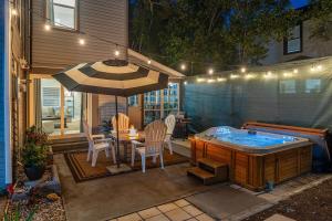 un patio con bañera de hidromasaje, mesa y sillas en Sea Haven House Beautiful Area Hot Tub Sunroom en Clearwater