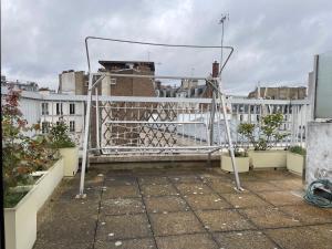 uma varanda com um portão de metal e alguns edifícios em Big apartment with terrace & central location em Paris