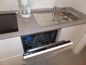 eine leere Spülmaschine in einer Küche neben einer Spüle in der Unterkunft Studio für 6 Personen ca 52 qm in Bibione, Adriaküste Italien Bibione und Umgebung in Bibione