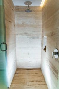 a bathroom with a shower with a wooden floor at Studio 2 blks 5th beach shops ac in Playa del Carmen