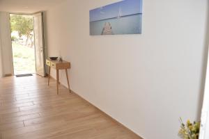 a hallway with a table and a picture on the wall at Gite Le soleillou in Reynès +1 photo