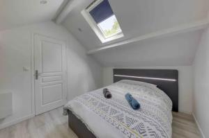 ein Schlafzimmer mit einem Bett mit zwei Schuhen drauf in der Unterkunft Maison avec jardin clos et privatif proche de Disneyland et parc des félins in Saint-Augustin