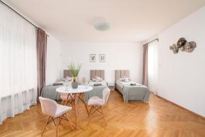 um quarto branco com uma mesa e duas cadeiras em Willa Zacisze - Pokoje Gościnne em Breslávia