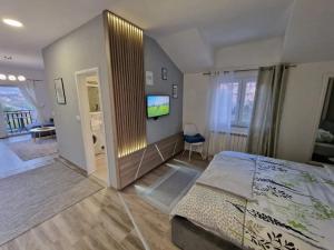 1 dormitorio con 1 cama y TV en Studio apartmani Milović, en Trebinje