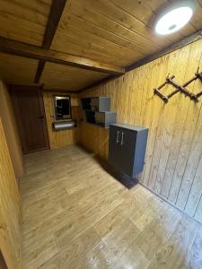 Habitación con paredes de madera y suelo de madera. en Villa Raiski kyt, en Dospat