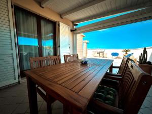 uma mesa de madeira num alpendre com vista para o oceano em THE TERRACE em Alba Adriatica