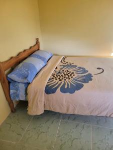 1 cama con marco de madera en una habitación en Tim's & Mag's Home Stay, en Roseau