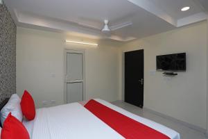a bedroom with a bed with red pillows at Flagship Richa Grand Inn Near Sahara Ganj Mall in Lucknow