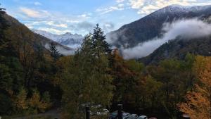 a view of a forest with clouds in the mountains at Nakanoyu Onsen Ryokan - Vacation STAY 18804v in Matsumoto