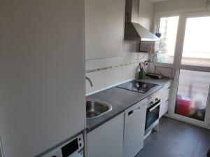 eine weiße Küche mit einem Waschbecken und einem Fenster in der Unterkunft apartamento familiar con piscina in Camarma de Esteruelas