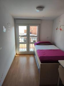 - une chambre avec un lit et une grande fenêtre dans l'établissement apartamento familiar con piscina, à Camarma de Esteruelas