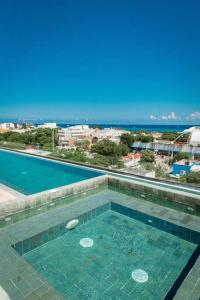 a swimming pool with a view of the ocean at 2BED 3BATH 2 blks 5th beach shop in Playa del Carmen