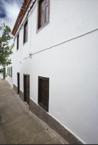 a white building with brown doors on a street at Casa Rama San Pedro in San Pedro
