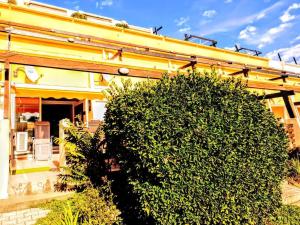 a house with a large bush in front of it at Phantasme Naturiste Studio Terrasse Port Nature in Cap d'Agde