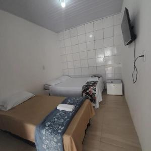 Kleines Zimmer mit 2 Betten und einem TV in der Unterkunft Pousada Estelita in Itaparica Town