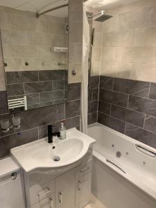 a bathroom with a sink and a bath tub at APPARTMENT IN LONDON in London