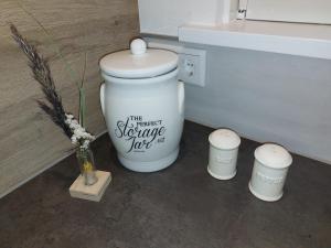 een wit toilet in een badkamer met een vaas met bloemen bij 't Uusje op de Werve in Aagtekerke