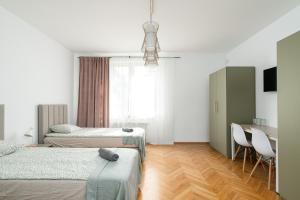 sypialnia z 2 łóżkami, stołem i biurkiem w obiekcie Willa Zacisze - Pokoje Gościnne we Wrocławiu