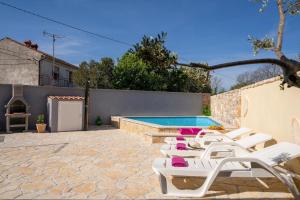 una fila di sedie a sdraio accanto alla piscina di Ferienhaus mit Privatpool für 5 Personen ca 100 qm in Butkovici, Istrien Binnenland von Istrien a Butkovići