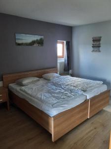 a bedroom with a large bed with white sheets at Große Ferienwohnung in Ludwigsreut mit Eigenem Balkon in Haidmühle