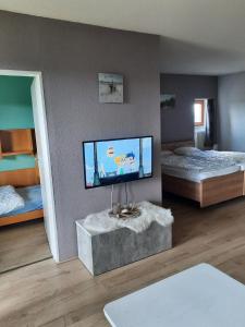 a room with two beds and a flat screen tv at Große Ferienwohnung in Ludwigsreut mit Eigenem Balkon in Haidmühle