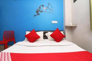 a bed with red pillows and a blue wall at OYO Sher E Bengal in Durgāpur