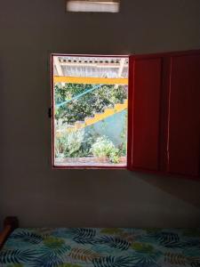 a bedroom with a window with a bed in front of it at Finca hostal La Alicia 1950 in Santa Marta
